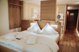 莱赫阿尔贝格戈尔登博格酒店的卧室配有白色大床和白色枕头