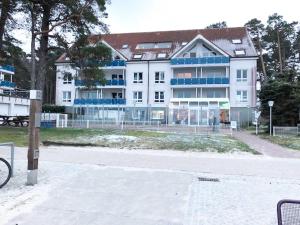卢布明Blaumuschel Haus A Wohnung 18 - DH的白色的大建筑,街道上设有蓝色窗户