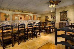 WoodwardNorthwest Inn的一间带木桌椅的餐厅和一间酒吧