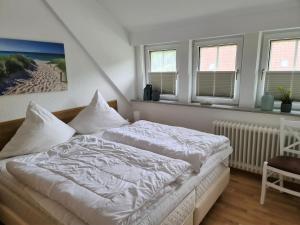 格洛米茨Bootshaus, App 4的一间卧室配有一张带白色床单和窗户的床。