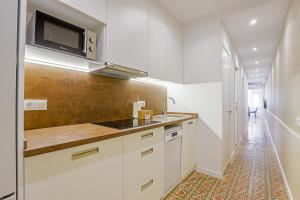巴塞罗那阿尔卡姆图书酒店的厨房配有白色橱柜和微波炉