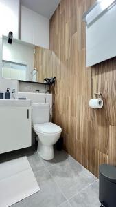 基辅CUBE House的浴室配有白色卫生间和木墙