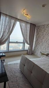 阿布扎比Reem Island 2BHK LUXURY APARTMENT!的一间卧室设有一张床和一个大窗户