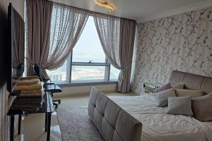 阿布扎比Reem Island 2BHK LUXURY APARTMENT!的一间带沙发和大窗户的卧室