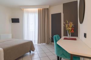 奇斯泰尼诺绿宝石酒店的酒店客房,配有床和鲜花桌