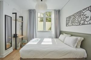 巴黎Hôtel Beauquartier Montmartre的卧室设有一张白色大床和一扇窗户。