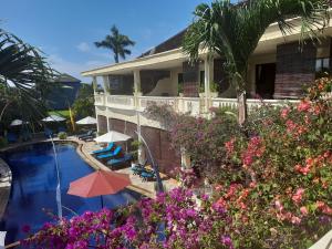 罗威那巴厘岛天堂精品度假酒店 的一座带游泳池和鲜花的度假村