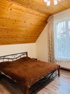 斯基希德尼萨Belvedere-Karpaty的一间卧室设有一张木天花板床。
