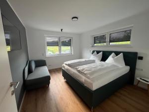 ObersammelsdorfVilla Turnersee的一间卧室配有一张床、一把椅子和窗户。