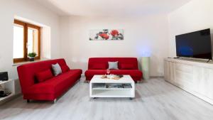 伊格莱西亚斯Casa di Elena的客厅配有2把红色椅子和电视