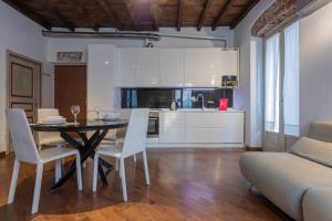都灵Elegante appartamento al Quadrilatero by Wonderful Italy的厨房以及带桌椅的用餐室。