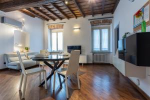 都灵Elegante appartamento al Quadrilatero by Wonderful Italy的用餐室以及带桌椅的起居室。