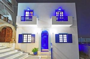 阿达玛斯moments rooms的白色的建筑,设有蓝色的门和楼梯