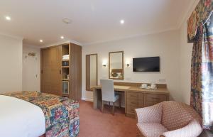 剑桥阿伦德尔官邸酒店的酒店客房配有一张床、一张书桌和一台电视。