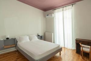 比雷埃夫斯Casanova94 Guesthouse的卧室配有白色的床和窗户。