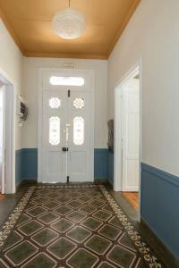 比雷埃夫斯Casanova94 Guesthouse的一条带白色门和地毯的走廊