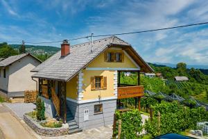 ČrnomeljVineyard Cottage Stepan - Happy Rentals的山丘上带阳台的黄色小房子