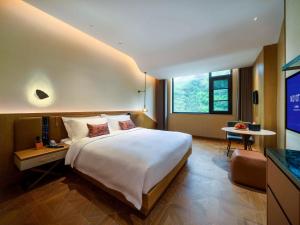 乡宁云丘山诺富特酒店的酒店客房设有一张大床和一台电视。