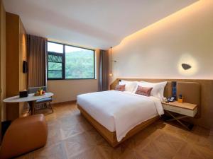 乡宁云丘山诺富特酒店的酒店客房设有一张大床和一张桌子。