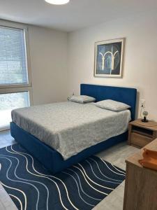 梅拉诺LabPark Luxury Apartment的一间卧室配有蓝色的床和地毯