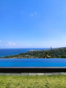圣吉吉阿亚古纳别墅旅馆的蓝色的游泳池,背景是大海