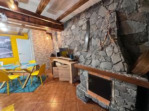 莫尼兹港Casa da Nogueira的厨房配有石制壁炉、桌子和椅子