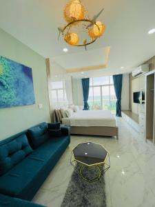 Ấp Ngọc HảiCăn Hộ Ocean Vista 1PN的客厅配有蓝色的沙发和床。