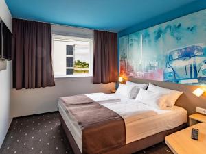 沃尔夫斯堡B&B Hotel Wolfsburg-Weyhausen的酒店客房设有床和窗户。
