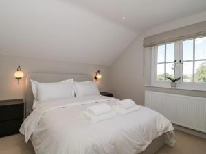 新米尔顿The Old Cottage的卧室配有白色的床和2条毛巾