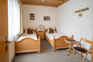 格拉弗瑙Landhaus Laih的一间卧室设有两张床、一把椅子和一个窗户。