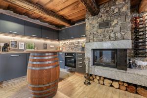 SemičVineyard Cottage Lan On The Hill - Happy Rentals的一间带石头壁炉和酒吧的厨房