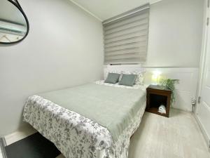 首尔JIBIDA Urban Inn的白色卧室配有床和镜子