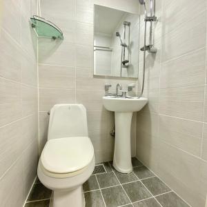 首尔JIBIDA Urban Inn的白色的浴室设有卫生间和水槽。