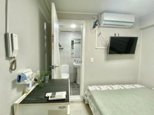首尔JIBIDA Urban Inn的小房间设有一张床和一间浴室