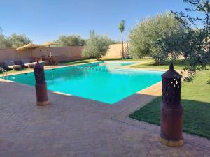 马拉喀什Magnifique villa à Marrakech的庭院里的一个蓝色海水游泳池