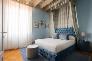 佛罗伦萨洛贾托迪赛维帝酒店的一间卧室配有一张大床和蓝色床头板