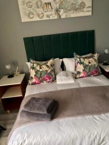 东伦敦Recoupe的一张带绿色床头板和枕头的大床