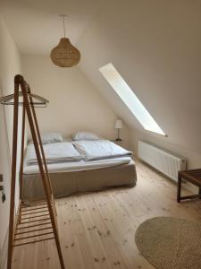 马斯塔尔Atma Guesthouse - cozy and simple bed & breakfast in the countryside的白色卧室设有床和天窗