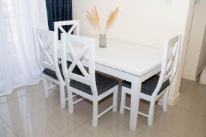 埃尔多雷特Staycation with les的白色的餐桌和四把白色的椅子