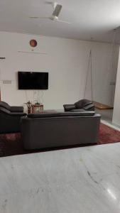 蓬蒂切里Ohm Shanthi Homestay的带沙发和平面电视的客厅
