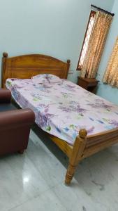 蓬蒂切里Ohm Shanthi Homestay的一间卧室设有一张木床和一个窗户。