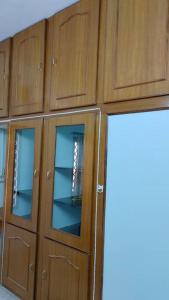 蓬蒂切里Ohm Shanthi Homestay的木柜,玻璃门在房间内