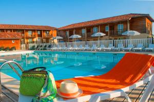欧兹阿马尼亚克塔高尔夫公寓的酒店带帽子和椅子的游泳池