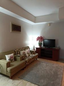 士姑来Ruey's Homestay, Cinta Ayu, Pulai Spring的带沙发和平面电视的客厅