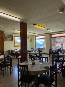 努奇堡Hostal Alt Llobregat的用餐室设有桌椅和窗户。