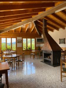 努奇堡Hostal Alt Llobregat的大房间设有桌椅和壁炉