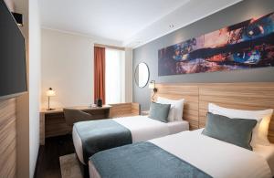 林茨Leonardo Boutique Hotel Linz City Center的一间酒店客房,设有两张床和电视