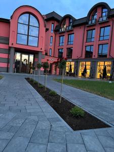 德罗霍贝奇Hotel Zefir的前面有棵树的粉红色建筑