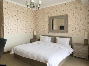 KachretʼiAmbassadori Kachreti Golf Resort的一间卧室配有一张带粉红色花卉壁纸的大床