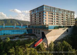 比尔根山Bürgenstock Hotel & Alpine Spa的前面有一辆红色火车的建筑